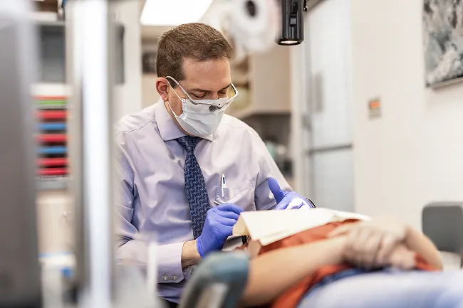 One of the orthodontists at Hulme Orthodontics examines a patient's smile in San Antonio, TX.