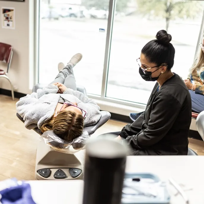 A team member at Hulme Orthodontics in San Antonio, TX discusses treatment with a patient.